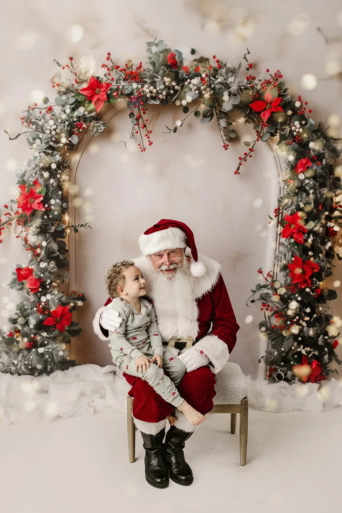 Santa Skip sharing a joyful Christmas moment with a young child beneath a festive wreath