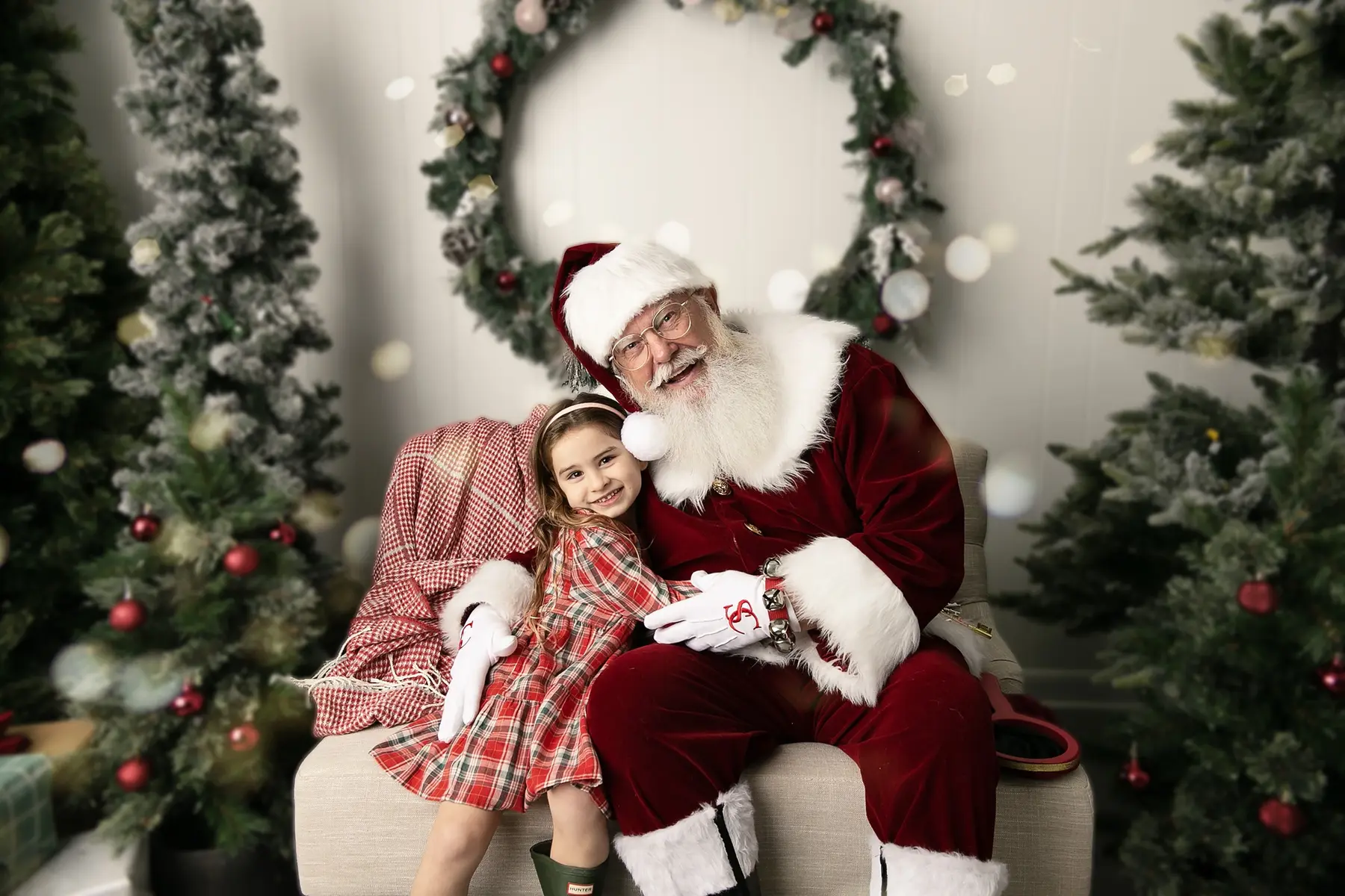 Santa Skip and a young girl smiling together in a Christmas portrait
